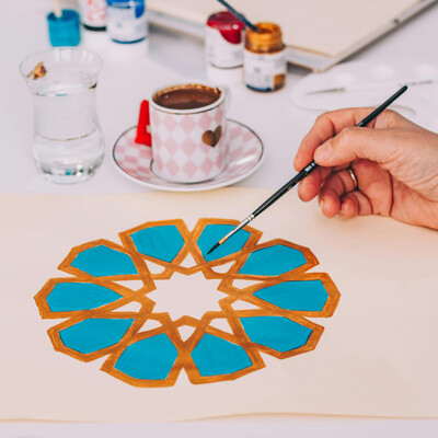 Hands painting a colourful mandala
