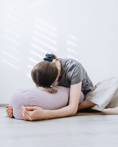 Woman resting on yoga bolster